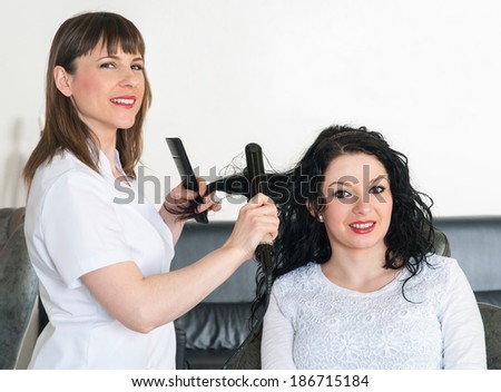 hairdresser straightens hair to a client