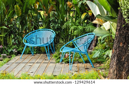 Blue chair with tree background in garden
