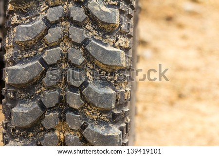 Tread tire coated in mud on an offroad
