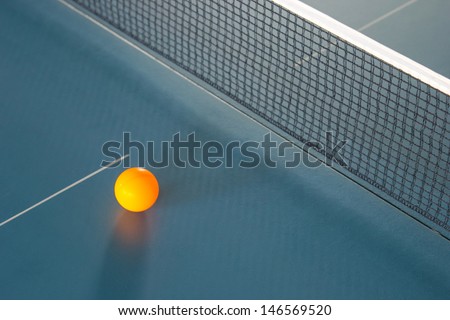 Orange table tennis ball on blue table