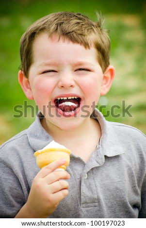 Child laughing while eating ice cream cone