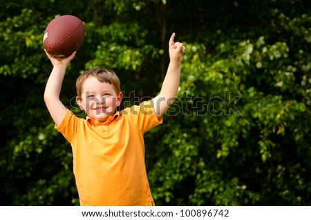 Child with football celebrating by showing that he's Number 1