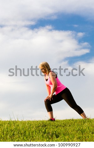 Middle-aged woman in her 40s stretching for exercise outdoors
