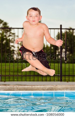 Child jumping into pool while going on swimming outing during summer