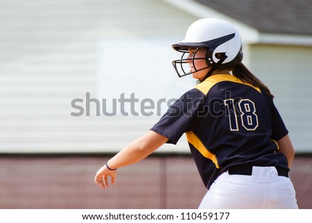Young teen girl playing softball in organized game