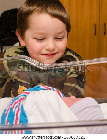 Excited boy meets his infant sibling for the first time after delivery at hospital