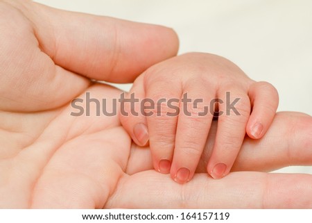 Close up of infant hand on top of mother\'s hand