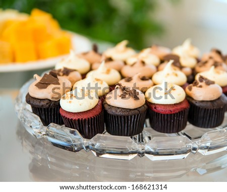 Mini cupcakes in glass tray on buffet