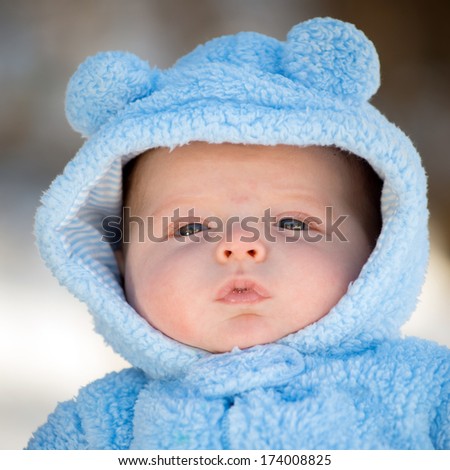 Cute infant baby boy wearing fluffy snow suit during winter