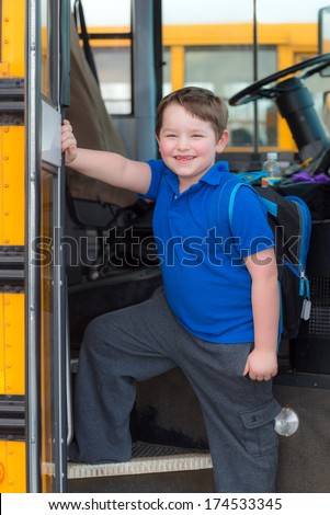 Happy child boarding school bus going back to school