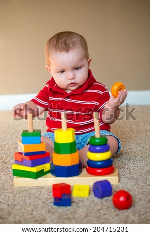 Baby boy playing with stacking learning toy