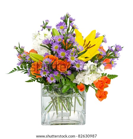 Colorful flower arrangement centerpiece  in square glass vase with roses, daisies and llilies isolated on white