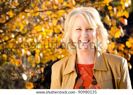 Fall portrait of happy middle-aged blonde woman
