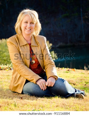 Fall portrait of happy middle-aged blonde woman