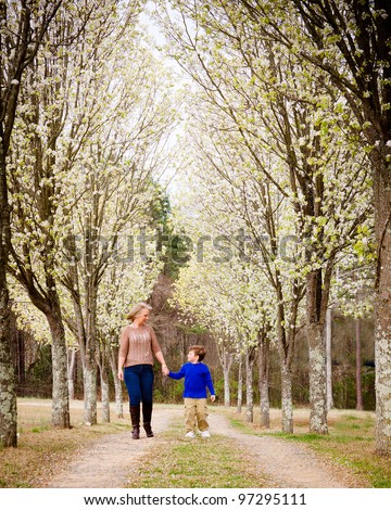 Mother and son walking hand in hand  at park during spring