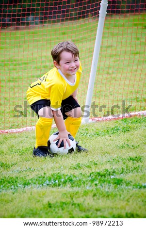 Young boy or kid playing soccer goalie