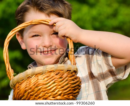 Child Boy kid holding up his easter basket after collecting eggs during Easter Egg hunt
