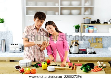 Young couple cooking - Men and women in the kitchen preparing food