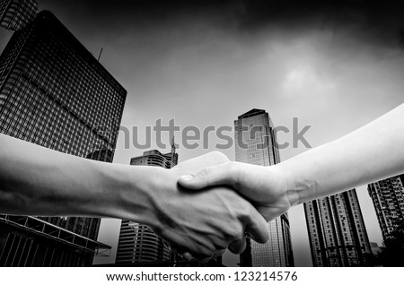 business people handshake black and white, on modern city