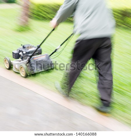 man garden worker cutting overgrown grass with lawn mower weeding machine blur motion