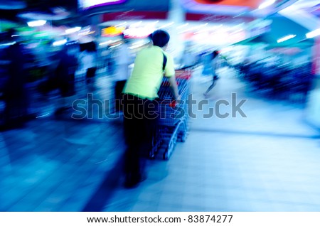 city crowd people with shopping cart blur motion