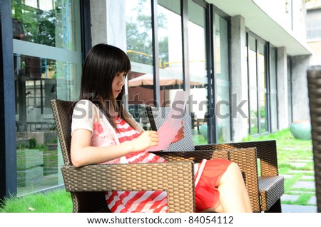 asian woman on chair with paper outdoor
