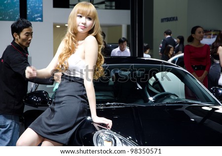 GUANGZHOU, CHINA - NOV 26: unidentified model with Porsche Cayman Black Edition sport car at the 9th China international automobile exhibition. on November 26, 2011 in Guangzhou China.
