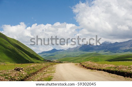 white cloud,mountain,grassland and clay road.