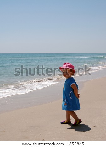 A young girl seeing the beach and the ocean for the first time takes in the new sights and sounds.