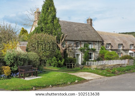 Traditional Thatched English Village Cottages with bench seat outside
