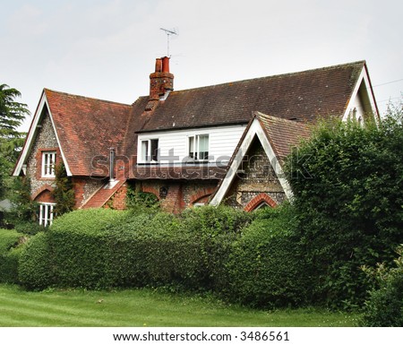English Brick and Flint House surrounded by a Shrub Hedge