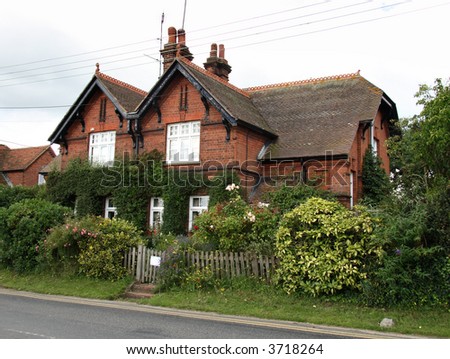 English Red Brick House surrounded by a Shrub Hedge