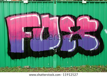 Graffitti on a construction site fence panel in an Urban Park in England