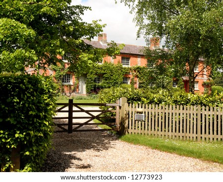 Traditional Red Brick English Village House with picket fence and five bar gate
