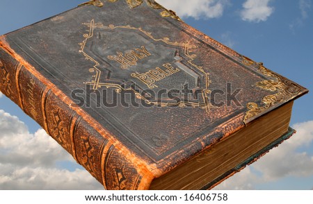 isolated image of an ancient leather bound Holy Bible with Brass inlays against the backdrop of a Heavenly Blue Sky