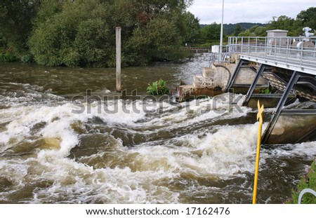 Raging Flood Water passing through a Weir on the River Thames in England