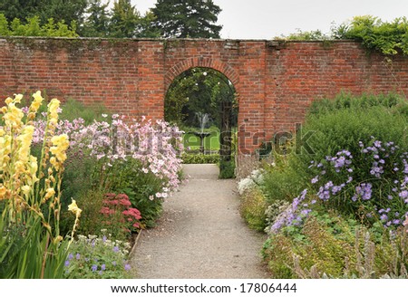 Pond and Fountain in an English Garden and archway through a wall 