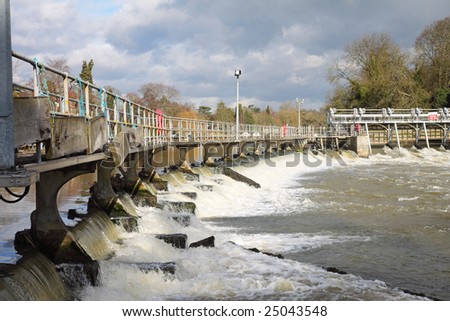 Flood waters passing through a Weir on the River Thames in England