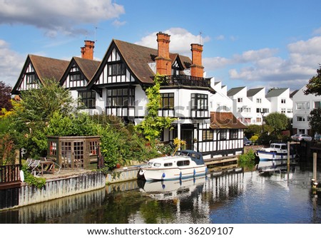 Black and white timber framed Riverside Houses and Moorings on the Banks of the River Thames in England