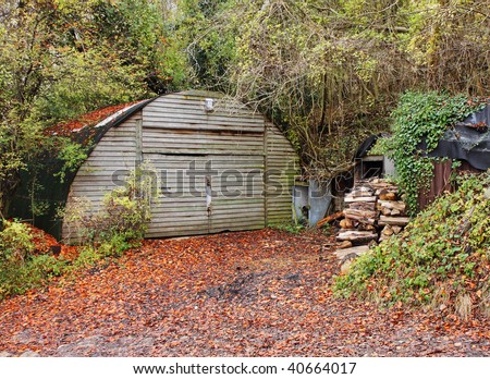 Stack of Firewood Logs outside a storage Shed in an English Wood in Autumn