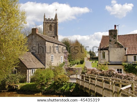 Traditional English Village with Church and Footbridge crossing a stream