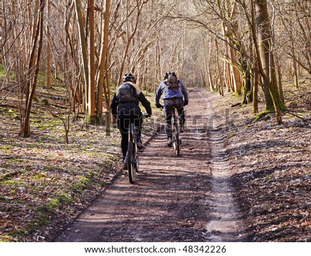 Two Mountain Bikers on a Woodland Trail in England