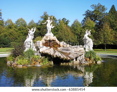 Ornate Shell shaped water feature in an English Landscape garden with statues of Cupids