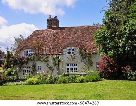 Traditional English Village Cottage and garden with Climbing roses on the Wall