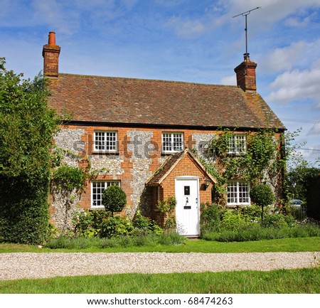 Traditional Brick and Flint English Village Cottage and garden with Climbing plants on the Wall