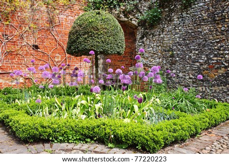 An english Walled garden with path leading to a water feature