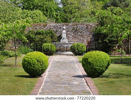 An english Walled garden with path leading to a water feature