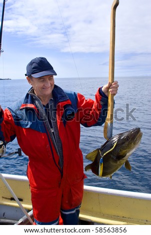 Fisherman with fish on the boat near the Lofoten island
