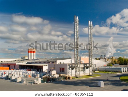 Factory with the shiny chimney and smoke in sunny day