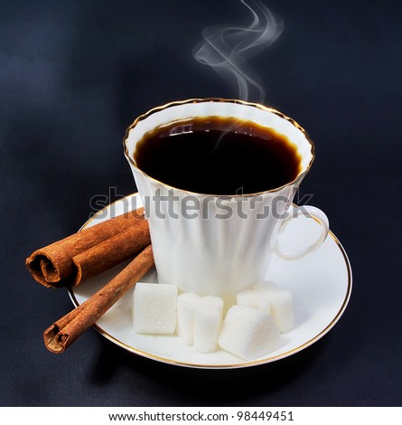 Cup of coffee with cinnamon sugar and slices of sugar